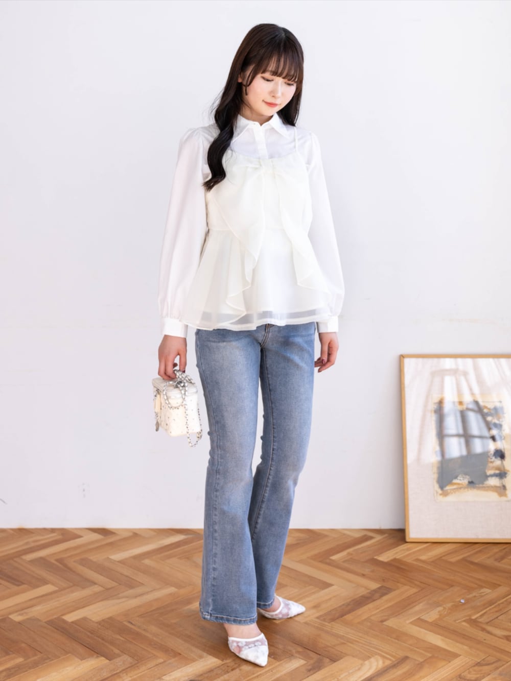 ブルー系のデニムパンツ、ホワイト系のシャツ/ブラウス、ホワイト系のパンプスを着用したレディースの春コーディネートの1枚目の写真