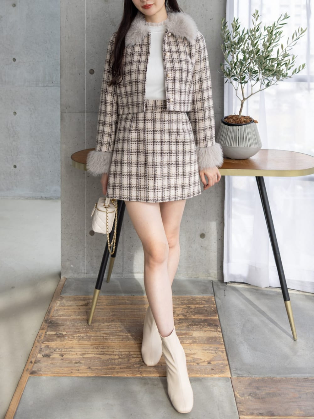 ホワイト系のブーツ、ベージュ系のスカート、ベージュ系のその他アウターを着用したレディースの秋コーディネートの1枚目の写真