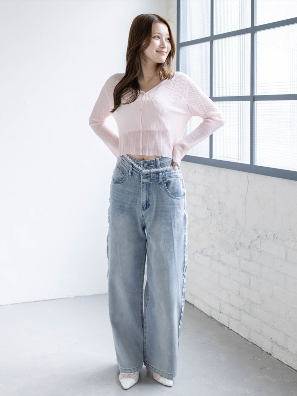 ブルー系のデニムパンツ、ホワイト系のパンプス、ピンク系のカーディガン/ボレロを着用したレディースの春コーディネートの1枚目の写真