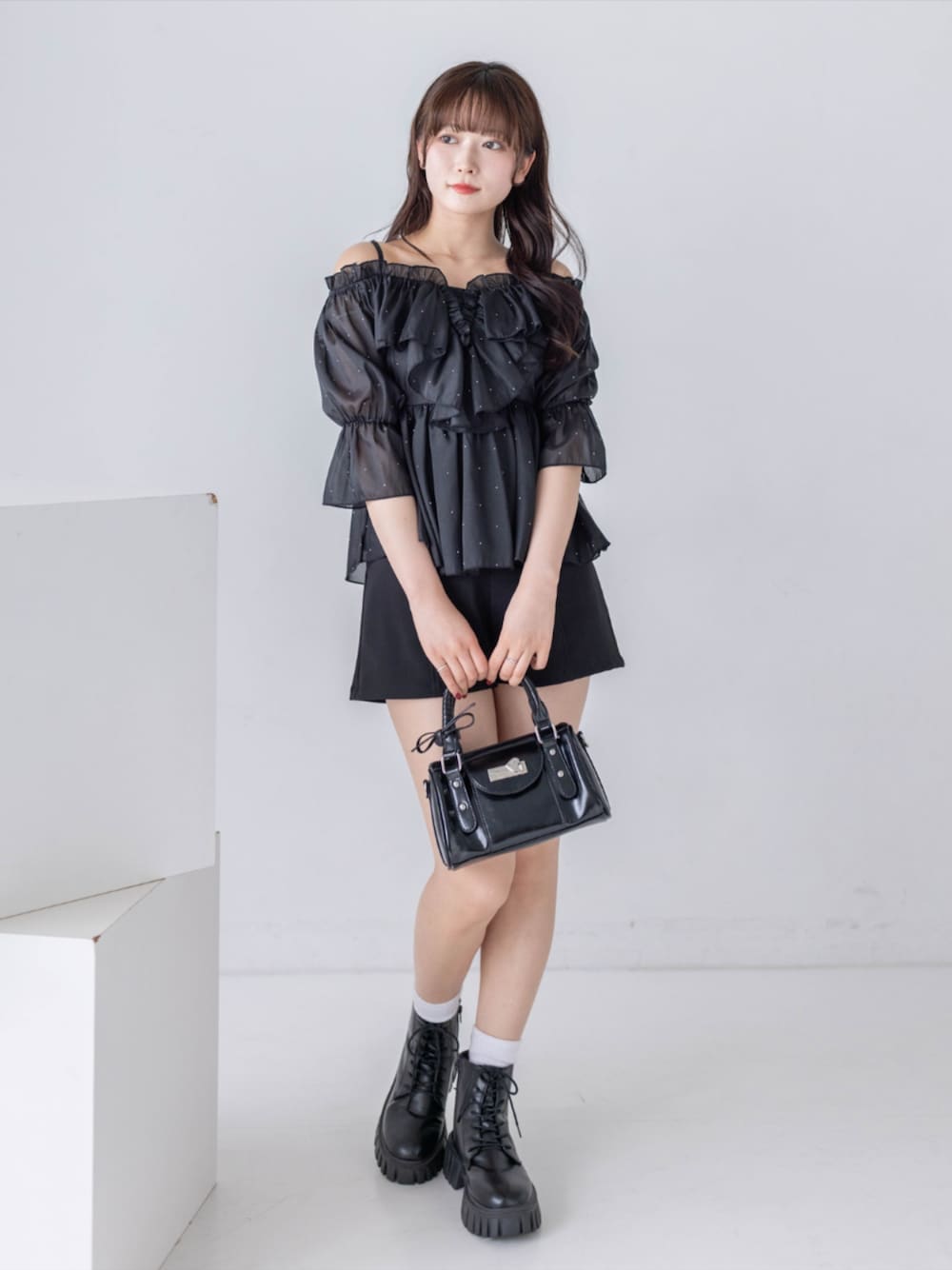 ブラック系のブーツ、ブラック系のその他パンツ、ブラック系のハンドバッグを着用したレディースの夏コーディネートの1枚目の写真