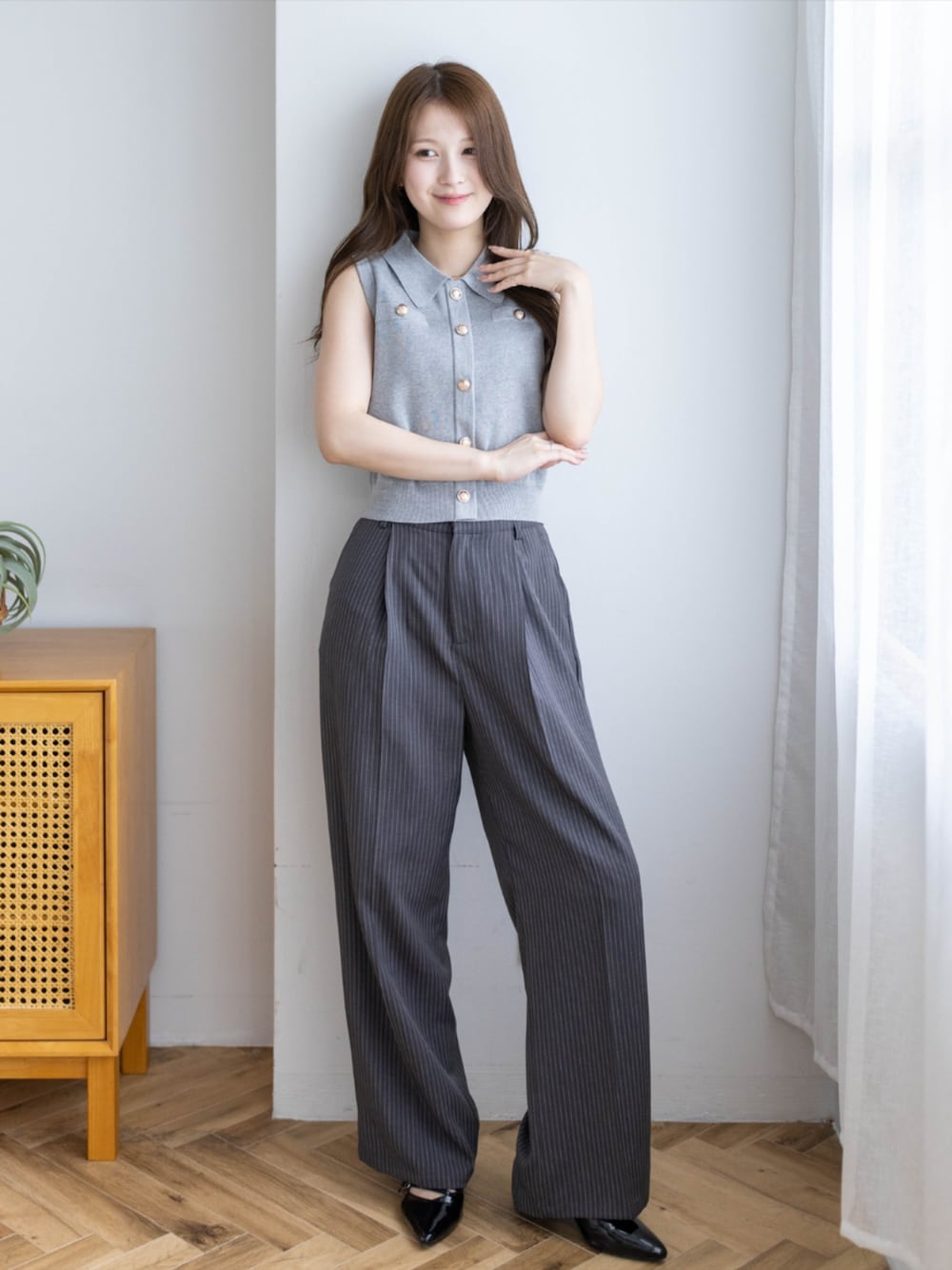 ブラック系のパンプス、グレー系のスラックス、グレー系のニット/セーターを着用したレディースの夏コーディネートの1枚目の写真