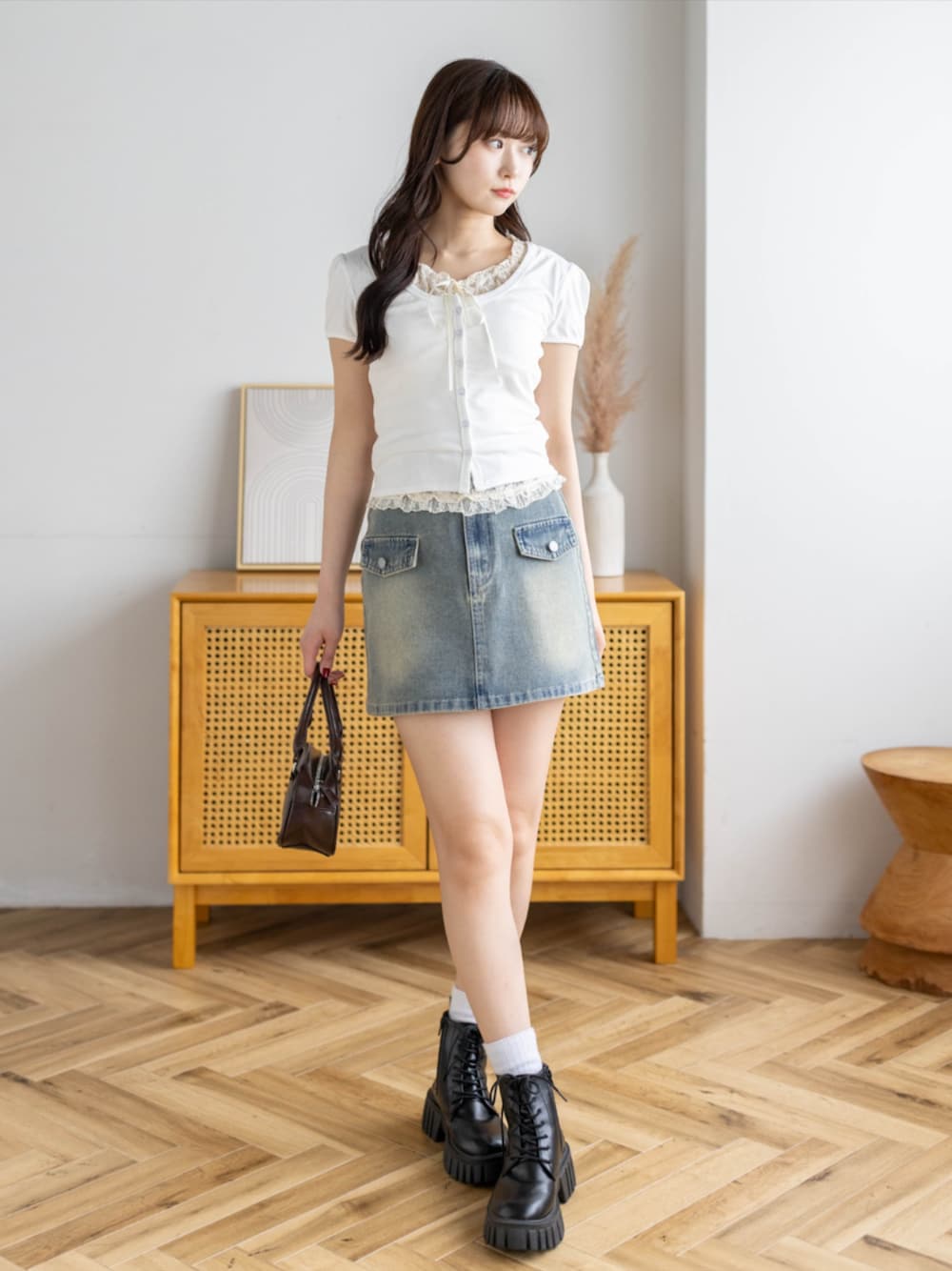 ブラック系のブーツ、ブルー系のスカート、ホワイト系のTシャツ/カットソーを着用したレディースの春コーディネートの1枚目の写真