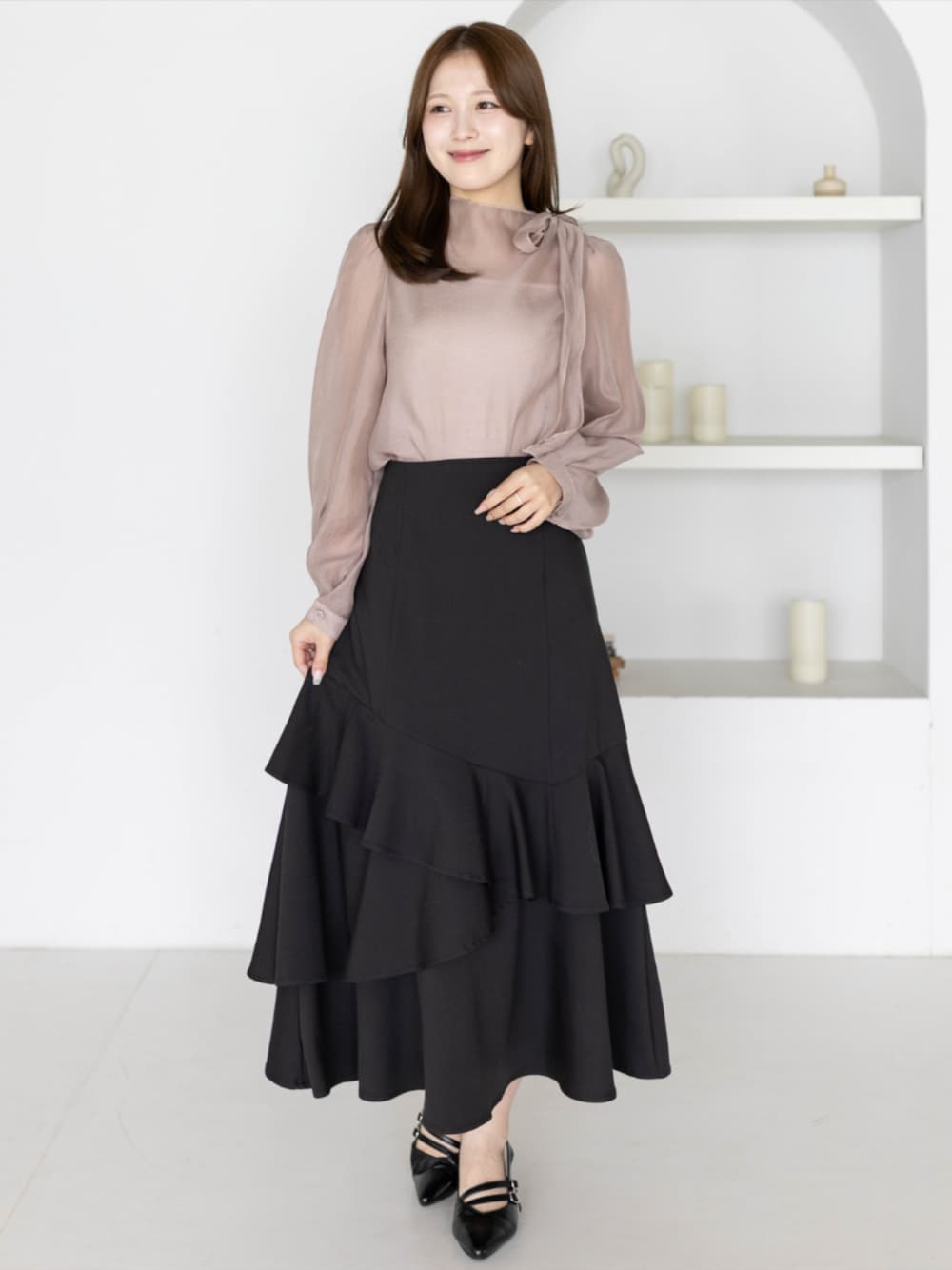 ブラック系のパンプス、ブラック系のスカート、ピンク系のシャツ/ブラウスを着用したレディースの夏コーディネートの1枚目の写真
