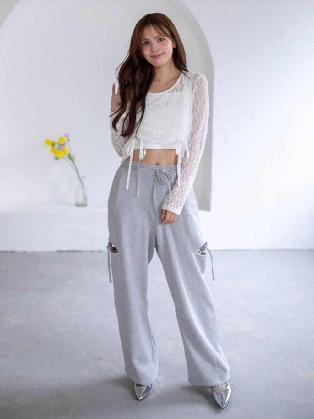 シルバー系のパンプス、ホワイト系のTシャツ/カットソー、グレー系のスウェットパンツを着用したレディースの春コーディネートの1枚目の写真