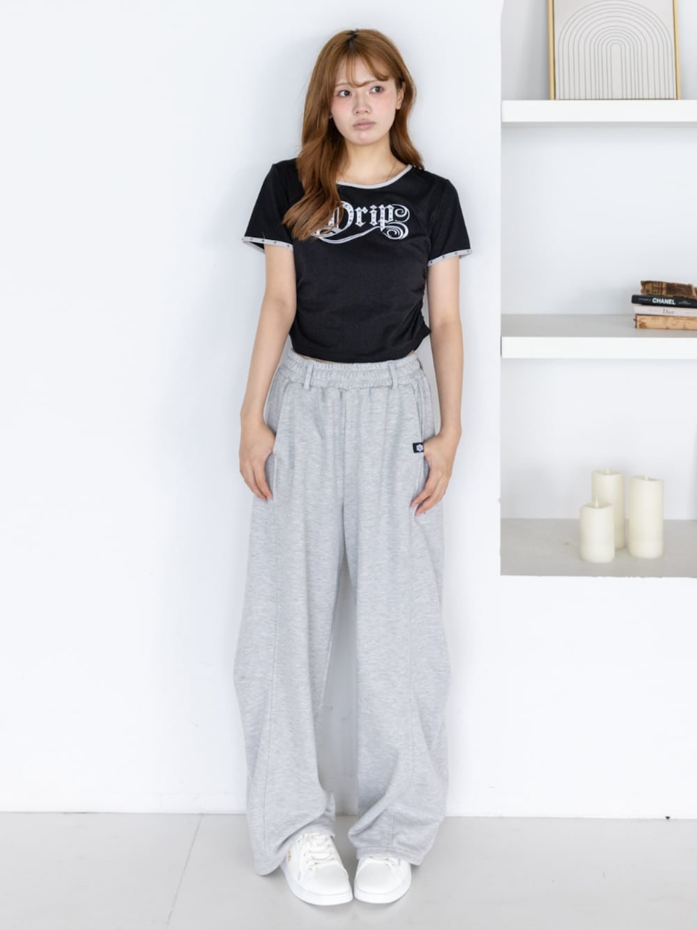 ゴールド系のスニーカー、グレー系のスウェットパンツ、ブラック系のTシャツ/カットソーを着用したレディースの夏コーディネートの1枚目の写真