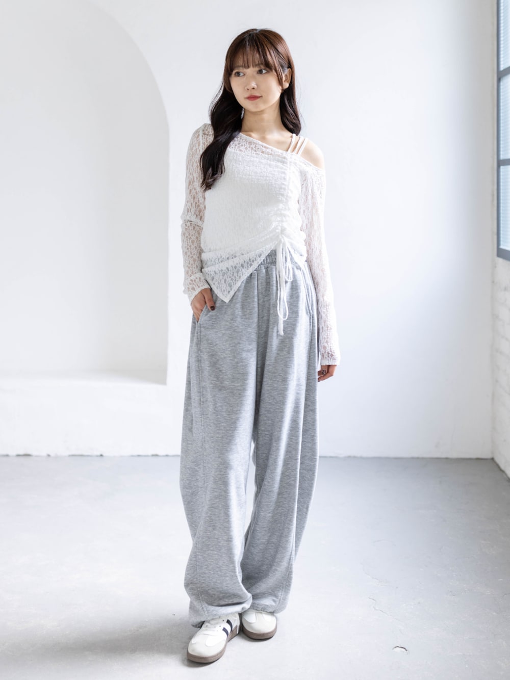 ホワイト系のスニーカー、グレー系のスウェットパンツ、ホワイト系のアンサンブルを着用したレディースの春コーディネートの1枚目の写真