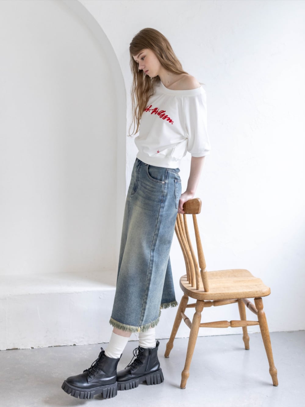 ブラック系のブーツ、ホワイト系のTシャツ/カットソー、ブルー系のデニムスカートを着用したレディースの夏コーディネートの1枚目の写真
