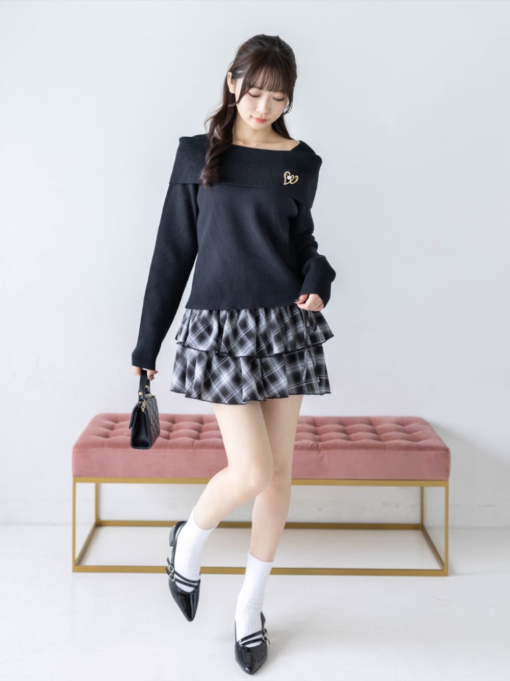 ブラック系のスカート、ブラック系のパンプス、ブラック系のニット/セーターを着用したレディースの秋コーディネートの1枚目の写真