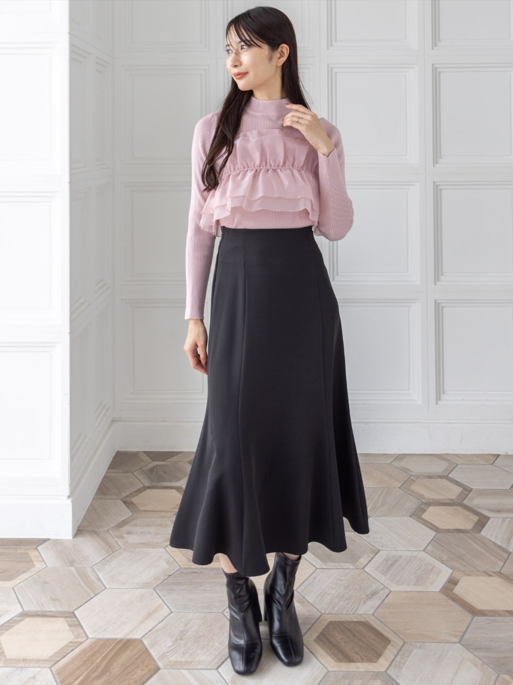 ブラック系のブーツ、ブラック系のスカート、ピンク系のニット/セーターを着用したレディースの秋コーディネートの1枚目の写真