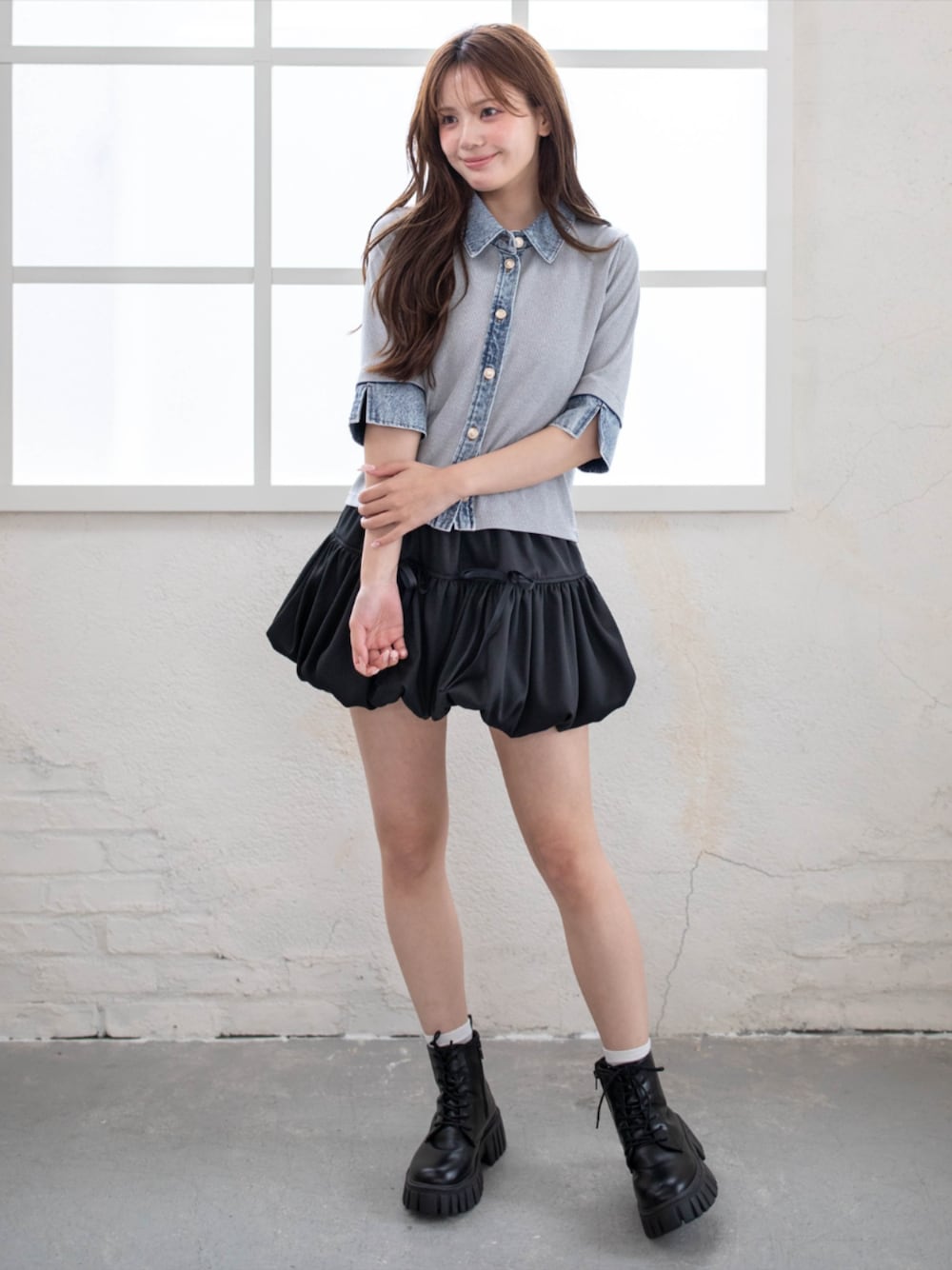 ブラック系のブーツ、ブラック系のスカート、グレー系のTシャツ/カットソーを着用したレディースの春コーディネートの1枚目の写真