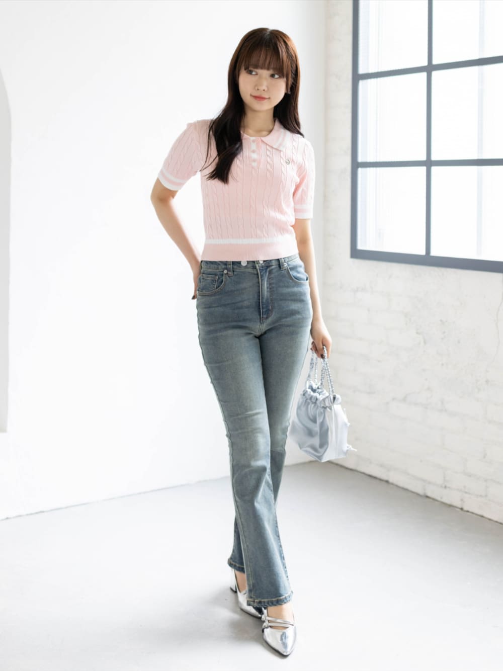 ブルー系のデニムパンツ、シルバー系のパンプス、ピンク系のニット/セーターを着用したレディースの夏コーディネートの1枚目の写真