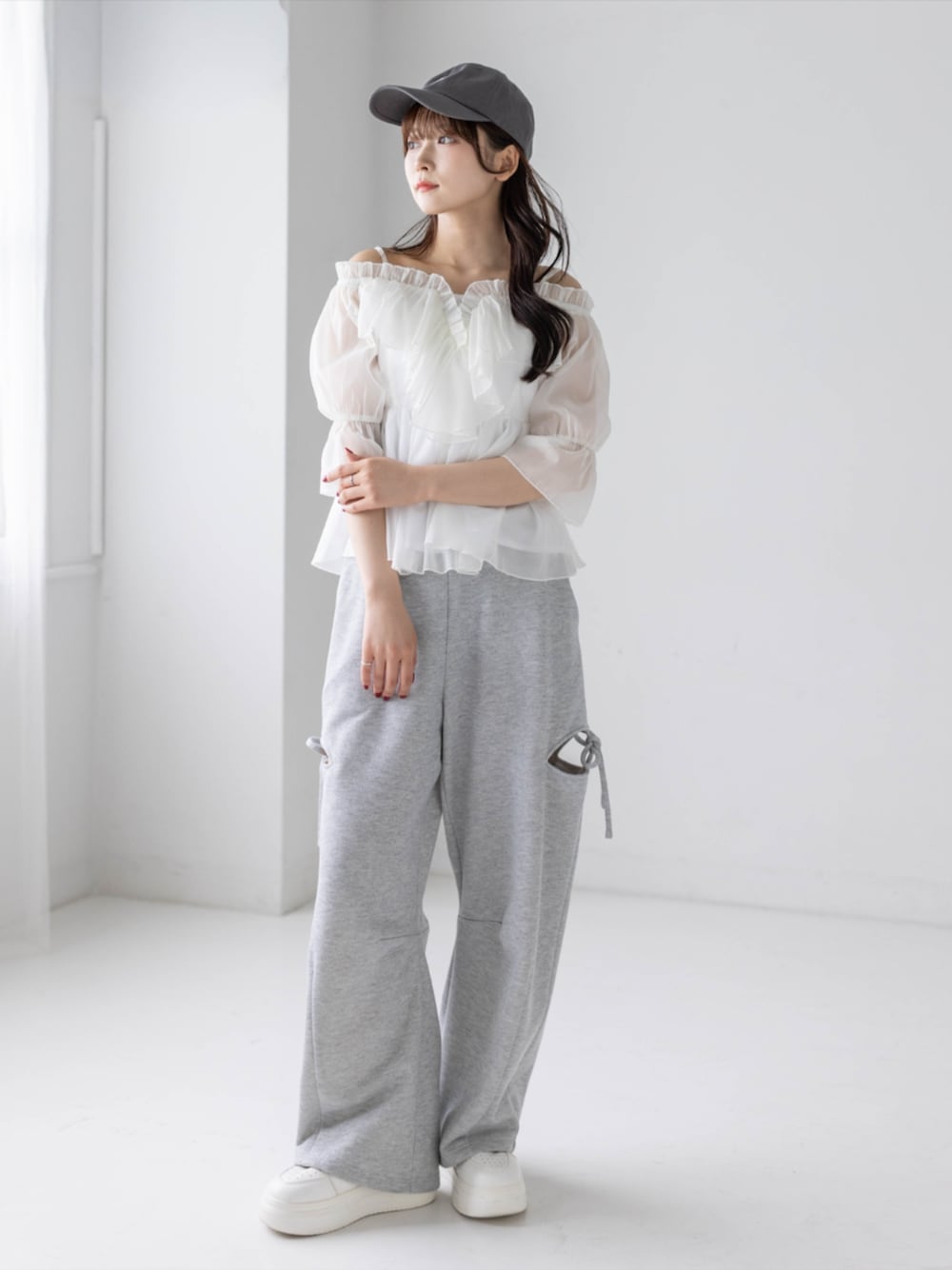 グレー系のスウェットパンツ、ホワイト系のシャツ/ブラウス、グレー系のキャップを着用したレディースの春コーディネートの1枚目の写真