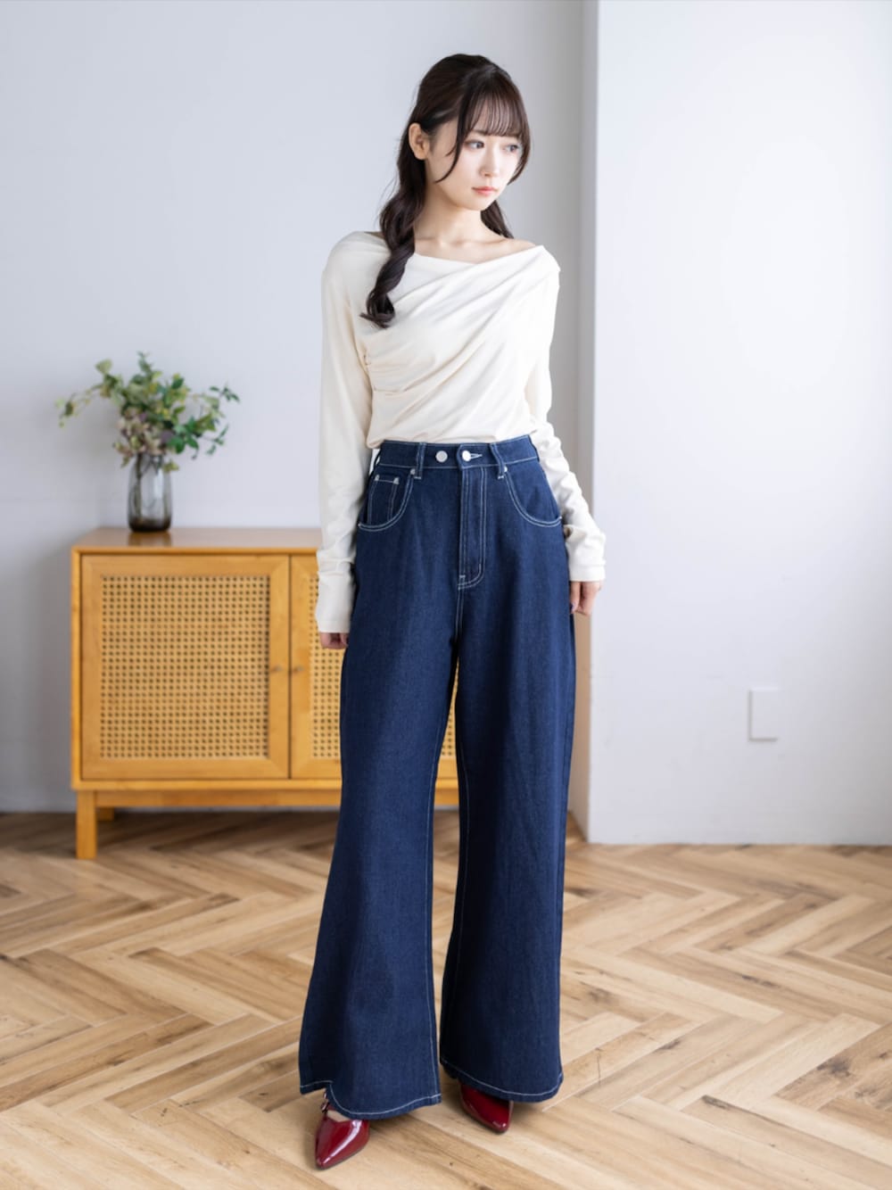 レッド系のパンプス、ブルー系のデニムパンツ、ホワイト系のTシャツ/カットソーを着用したレディースの秋コーディネートの1枚目の写真