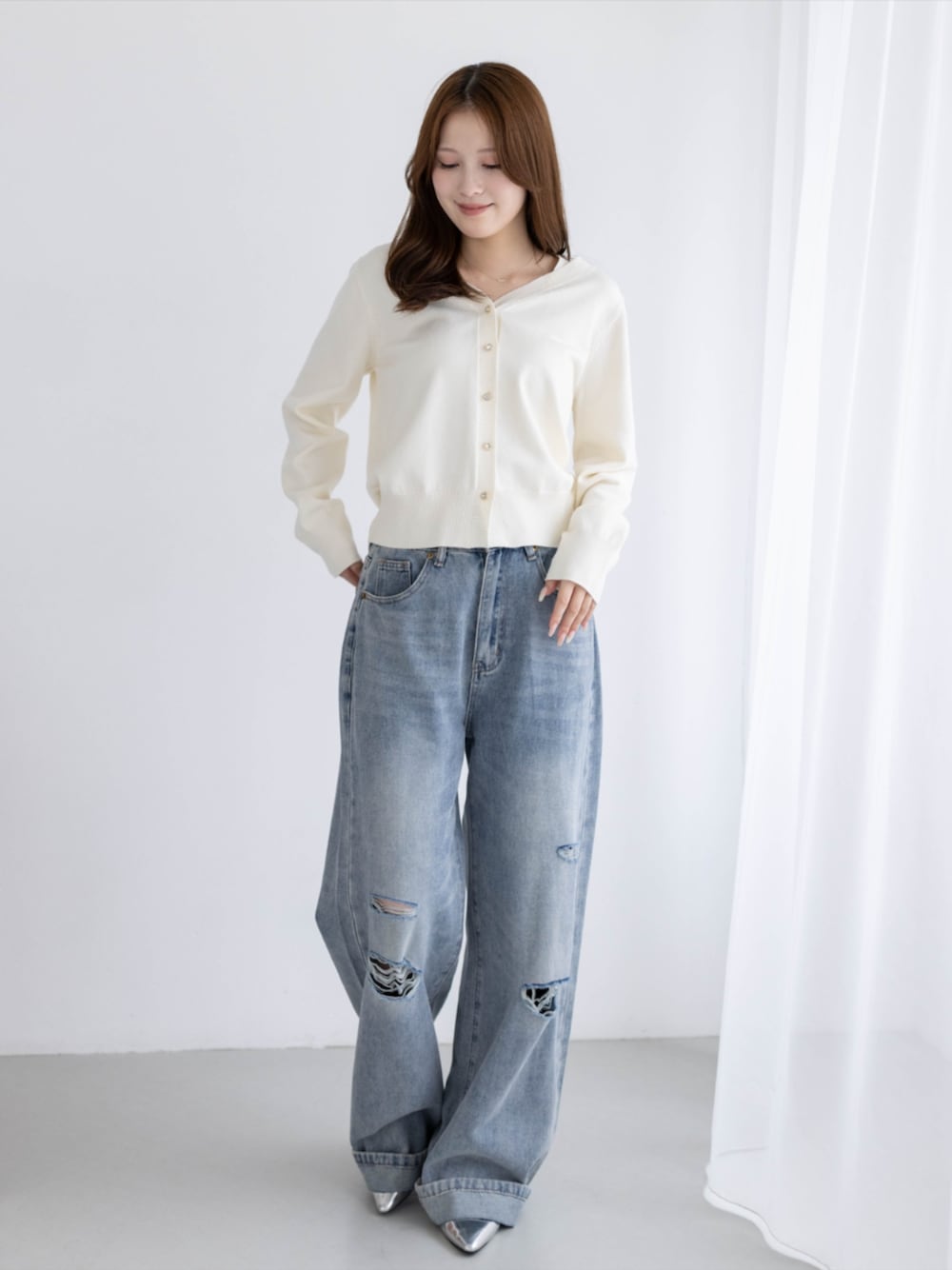シルバー系のパンプス、ブルー系のデニムパンツ、ホワイト系のカーディガン/ボレロを着用したレディースの秋コーディネートの1枚目の写真