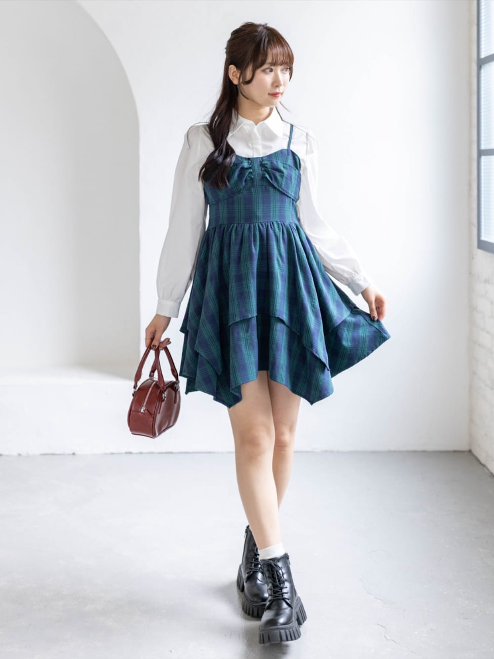 グリーン系のワンピース、ブラック系のブーツ、ホワイト系のシャツ/ブラウスを着用したレディースの春コーディネートの1枚目の写真