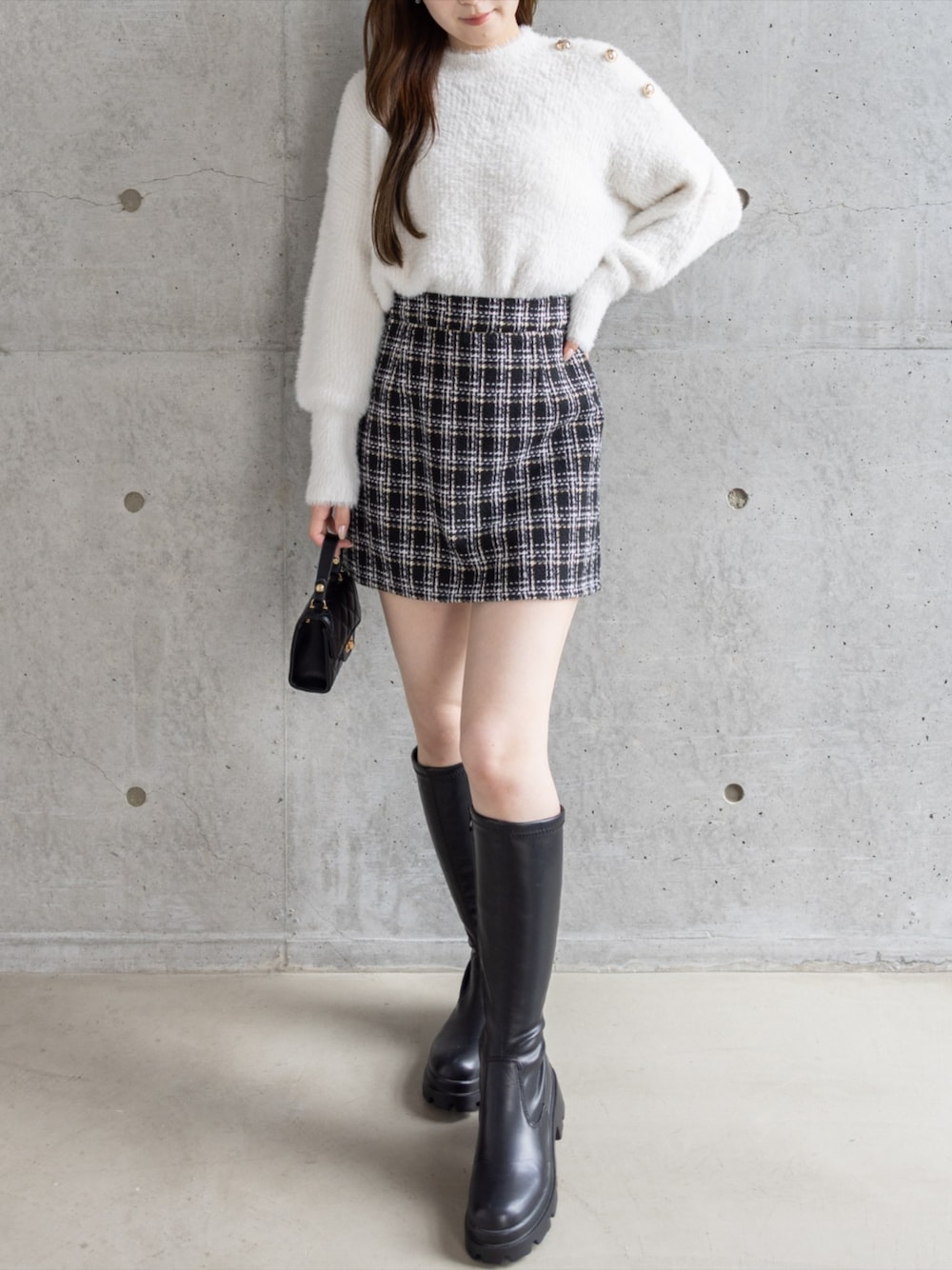 ブラック系のブーツ、ブラック系のショルダーバッグ、ブラック系のスカートを着用したレディースの秋コーディネートの1枚目の写真