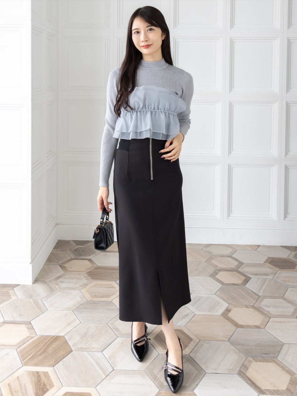 ブラック系のスカート、ブラック系のサンダル、ブラック系のショルダーバッグを着用したレディースの秋コーディネートの1枚目の写真