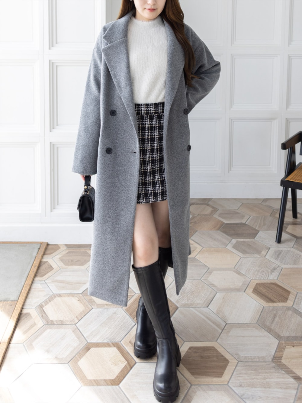 ブラック系のブーツ、ブラック系のショルダーバッグ、ブラック系のスカートを着用したレディースの冬コーディネートの1枚目の写真