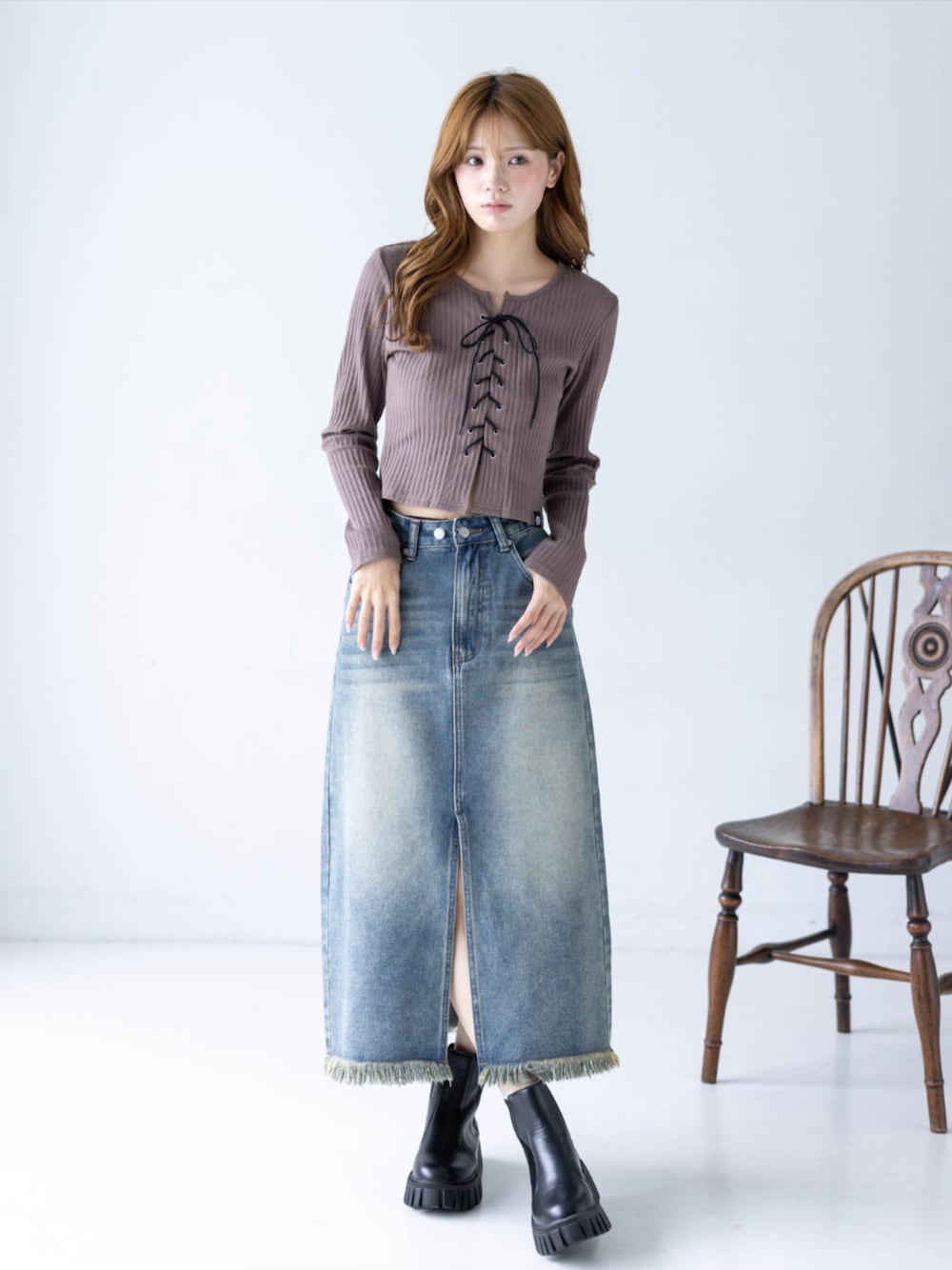 ブルー系のデニムスカート、ブラウン系のTシャツ/カットソー、ブラック系のブーツを着用したレディースの秋コーディネートの1枚目の写真