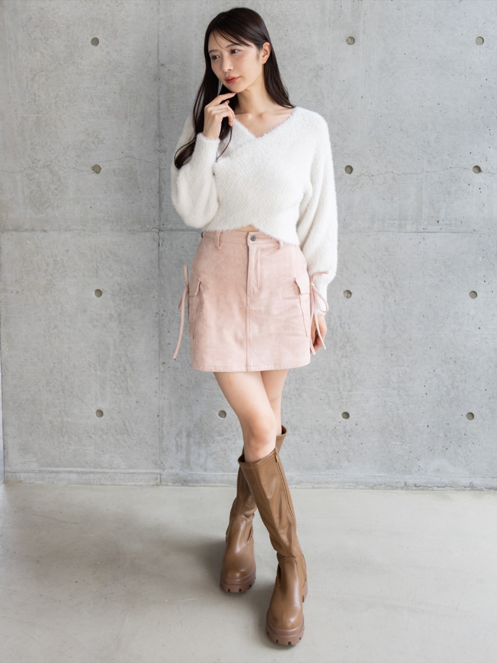 イエロー系のブーツ、ピンク系のスカート、ホワイト系のニット/セーターを着用したレディースの秋コーディネートの1枚目の写真
