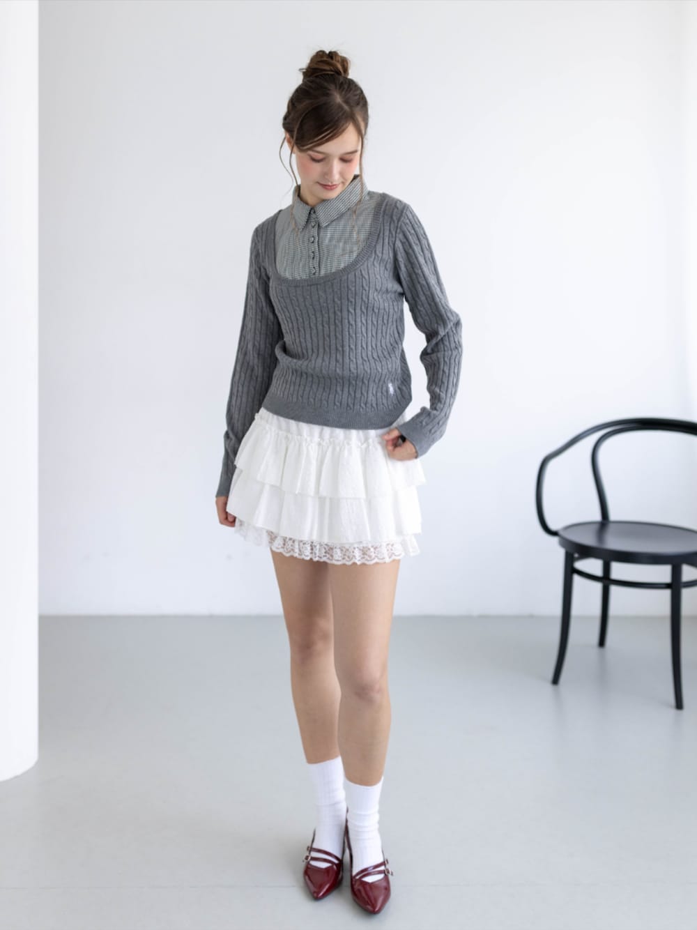 レッド系のパンプス、ホワイト系のスカート、グレー系のニット/セーターを着用したレディースの秋コーディネートの1枚目の写真