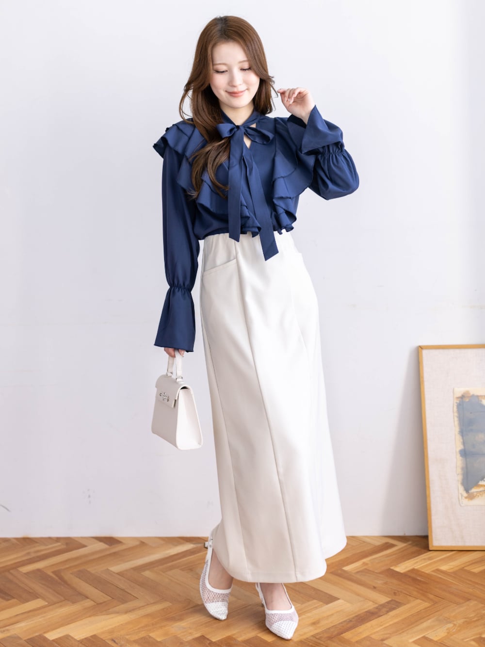 ブルー系のシャツ/ブラウス、ホワイト系のスカートを着用したレディースの冬コーディネートの1枚目の写真