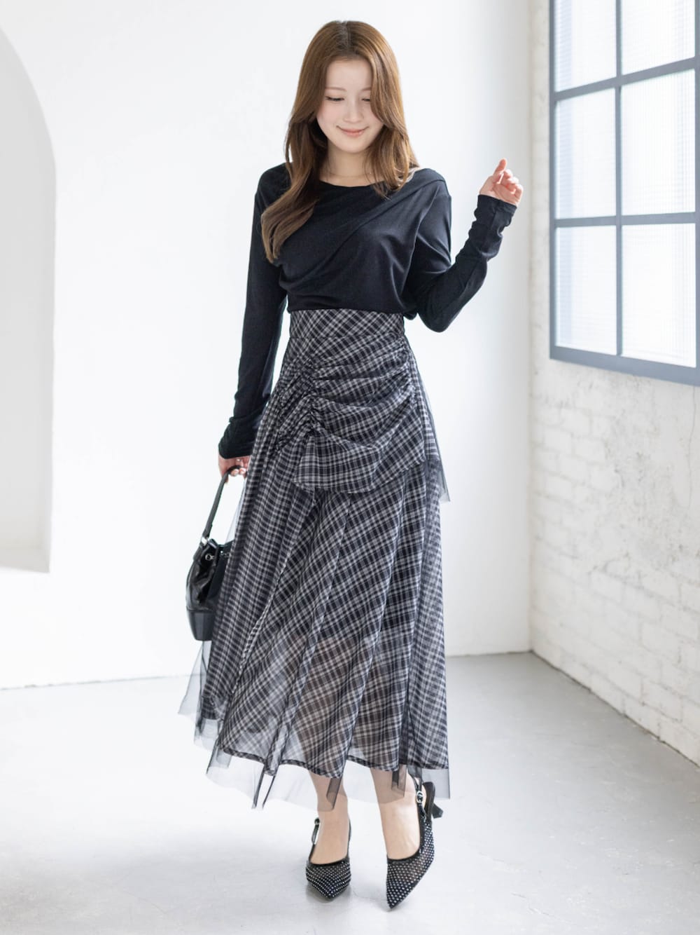 ブラック系のハンドバッグ、ブラック系のTシャツ/カットソー、ブラック系のスカートを着用したレディースの春コーディネートの1枚目の写真