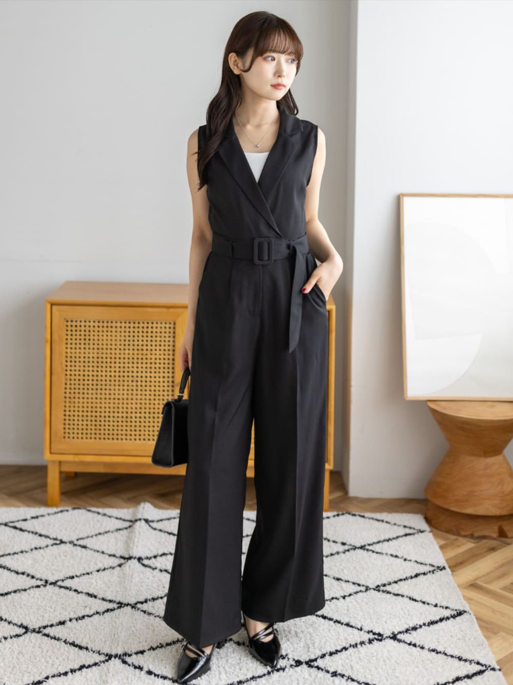 ブラック系のパンプス、ブラック系のハンドバッグ、ブラック系のつなぎ/オールインワンを着用したレディースの夏コーディネートの1枚目の写真
