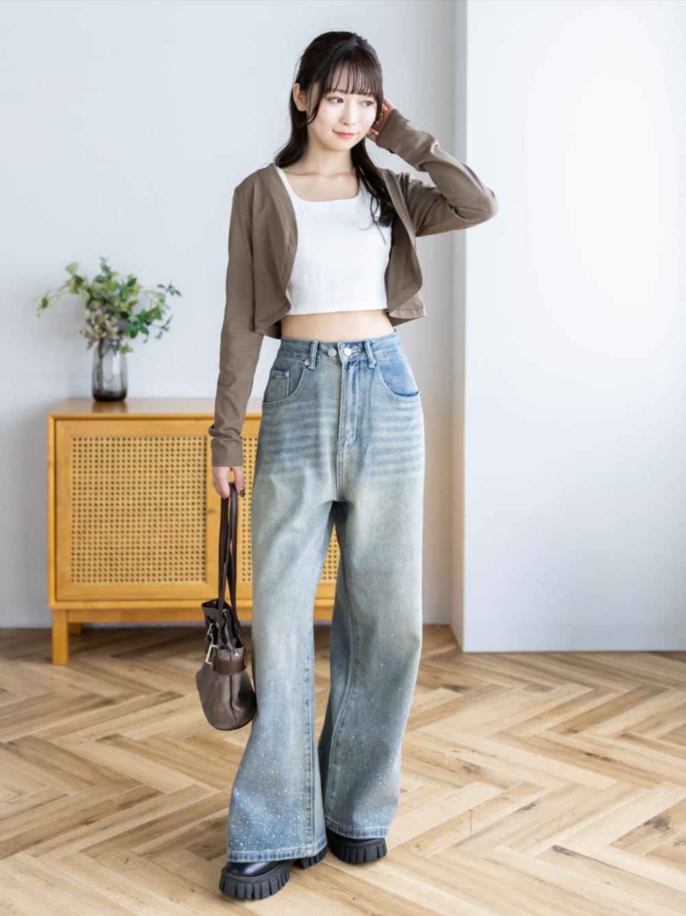 ブラウン系のショルダーバッグ、ブルー系のデニムパンツ、ブラウン系のカーディガン/ボレロを着用したレディースの夏コーディネートの1枚目の写真