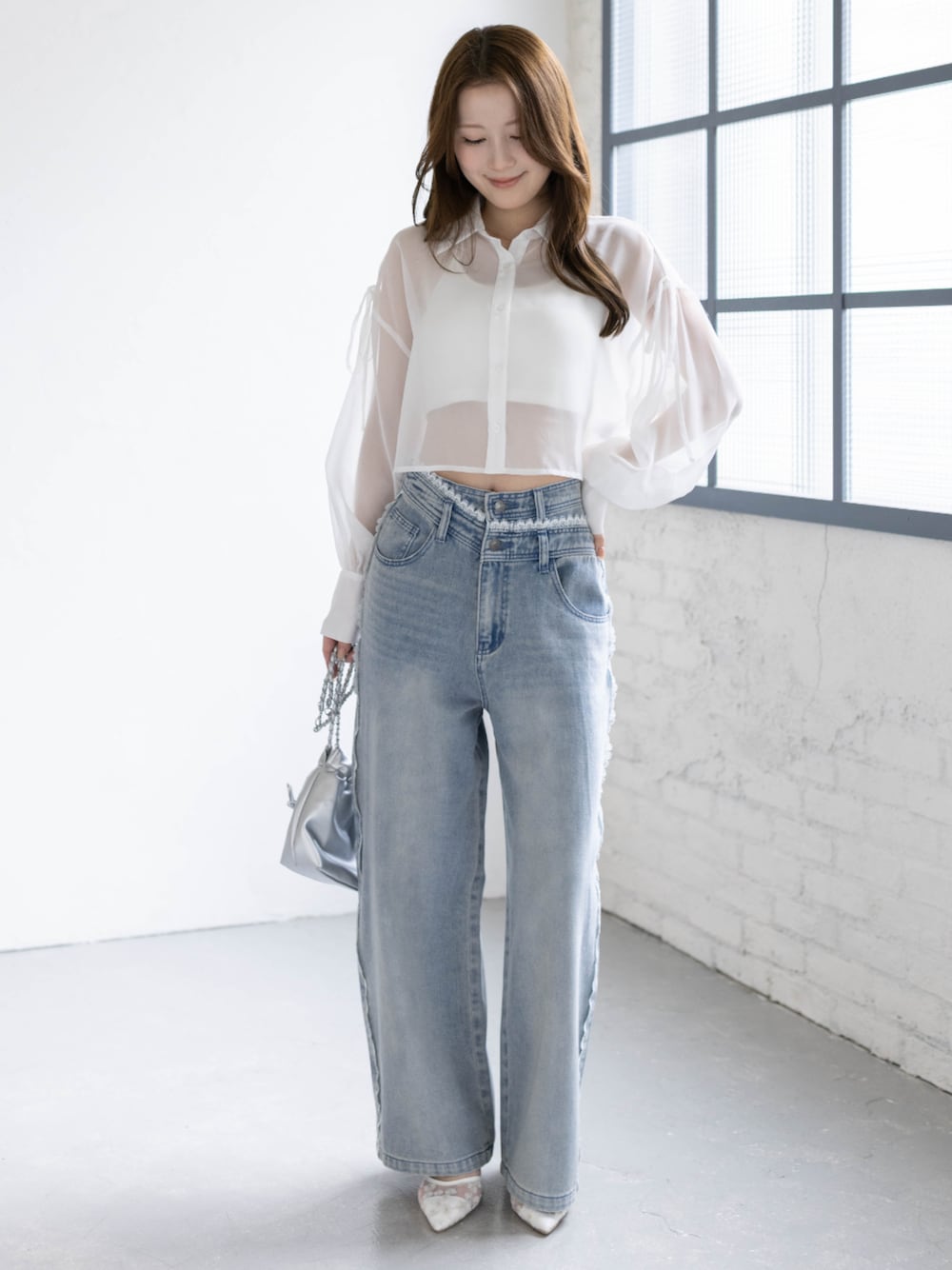 ブルー系のデニムパンツ、ホワイト系のパンプス、ホワイト系のシャツ/ブラウスを着用したレディースの春コーディネートの1枚目の写真