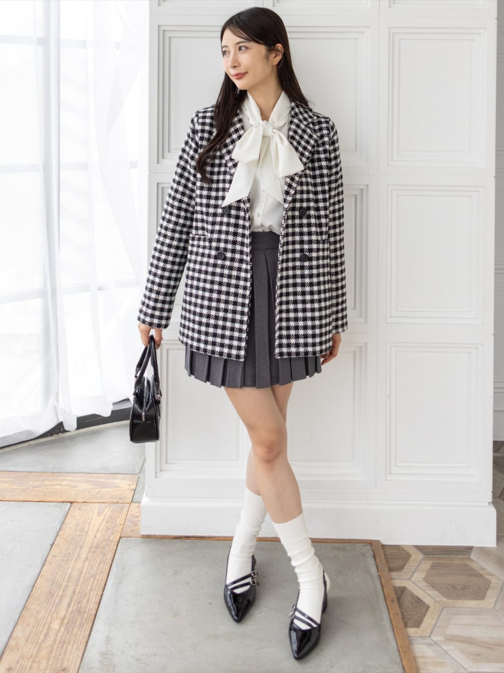 ホワイト系のシャツ/ブラウス、ブラック系のサンダル、ブラック系のハンドバッグを着用したレディースの秋コーディネートの1枚目の写真