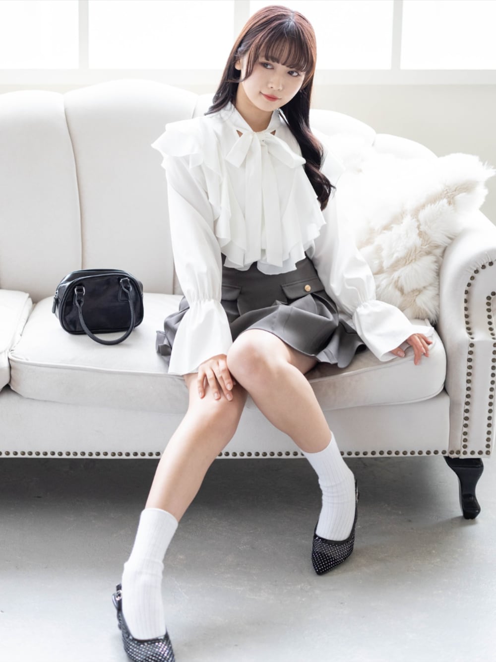 ブラック系のパンプス、グレー系のスカート、ホワイト系のシャツ/ブラウスを着用したレディースの夏コーディネートの1枚目の写真