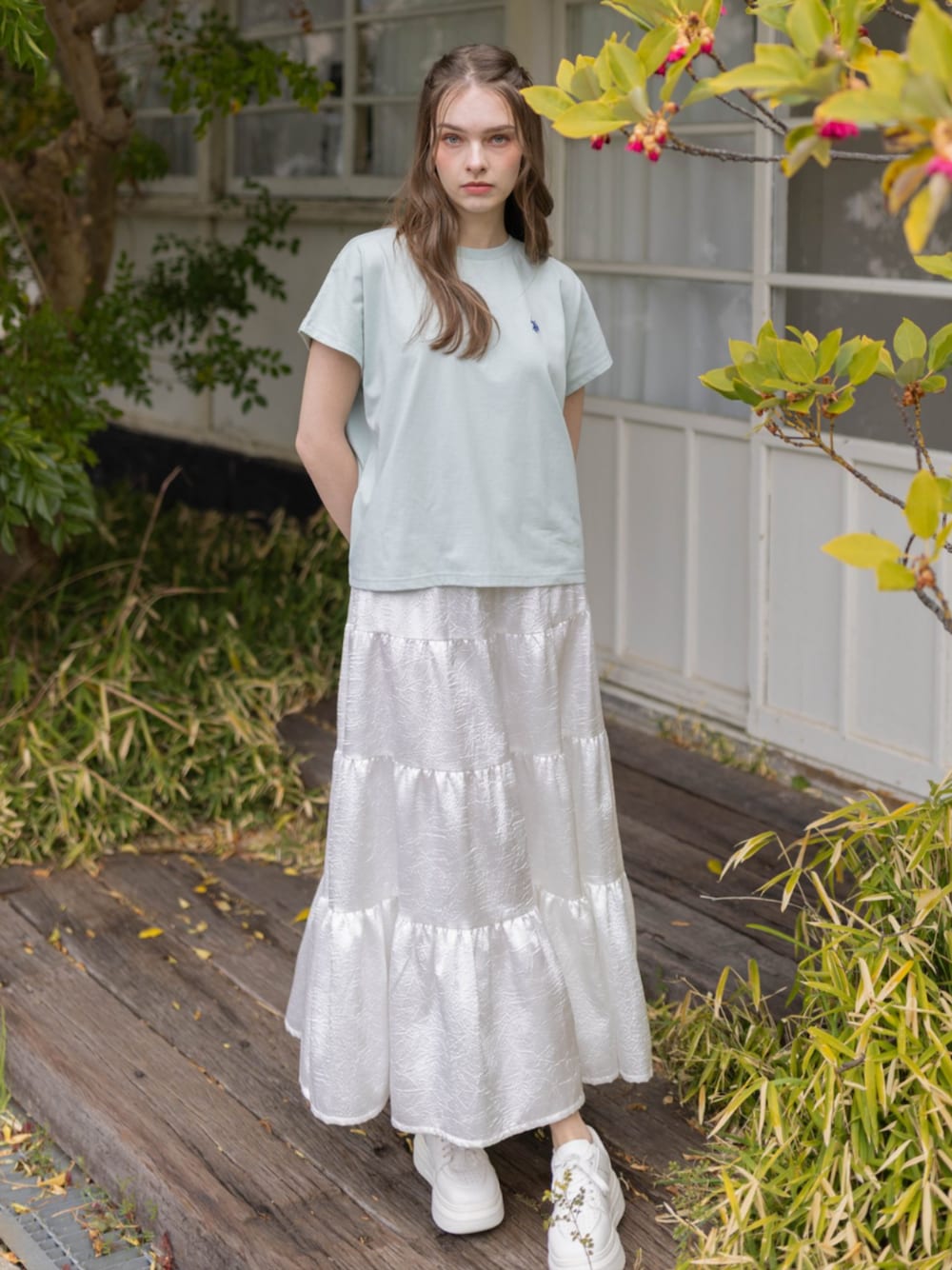 ホワイト系のスカート、グリーン系のTシャツ/カットソーを着用したレディースの夏コーディネートの1枚目の写真