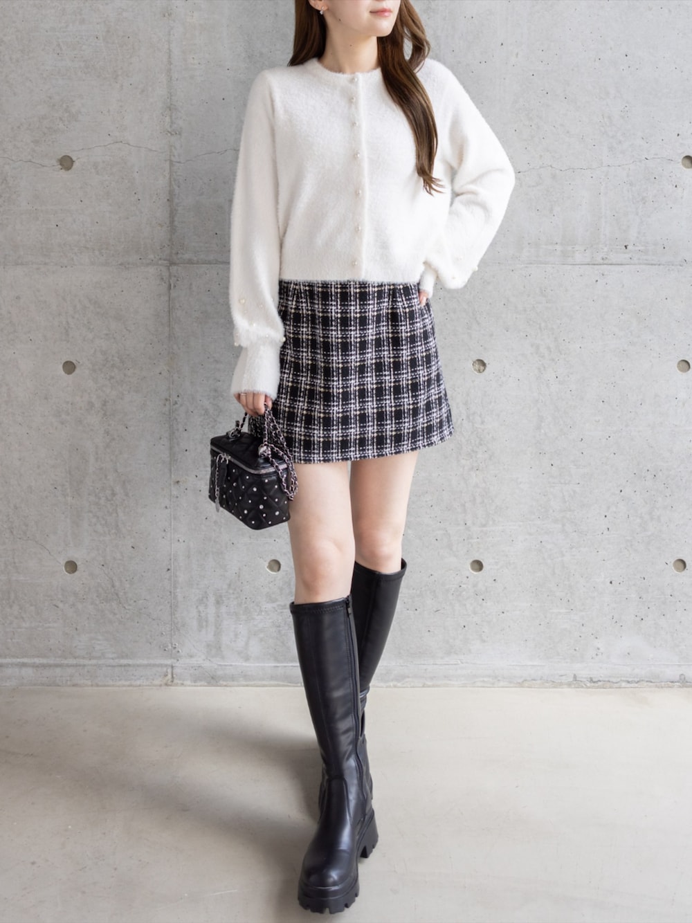 ブラック系のブーツ、ブラック系のショルダーバッグ、ブラック系のスカートを着用したレディースの秋コーディネートの1枚目の写真