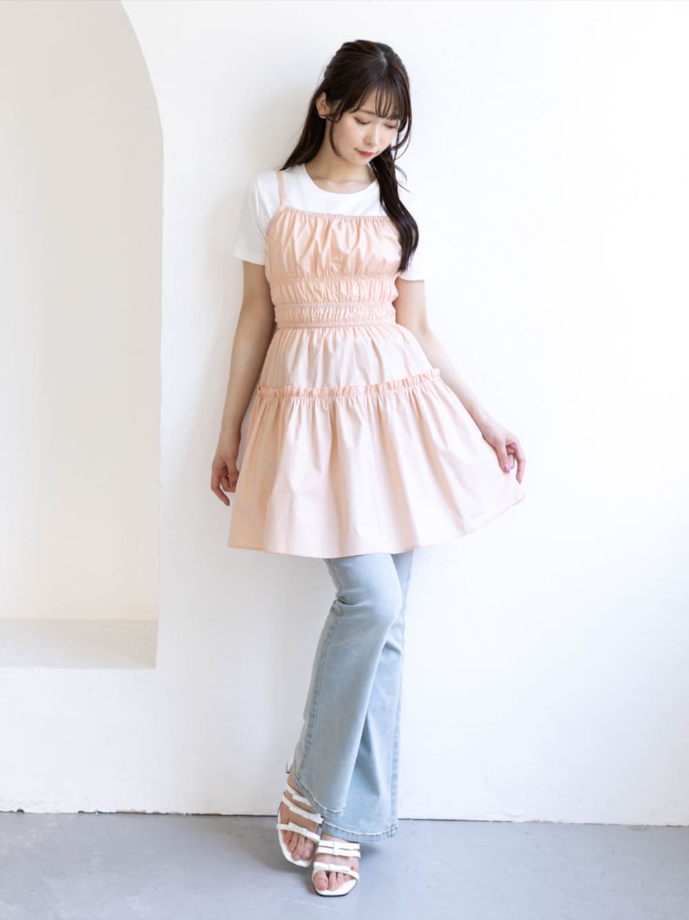 ブルー系のデニムパンツ、ホワイト系のサンダル、ピンク系のワンピースを着用したレディースの夏コーディネートの1枚目の写真
