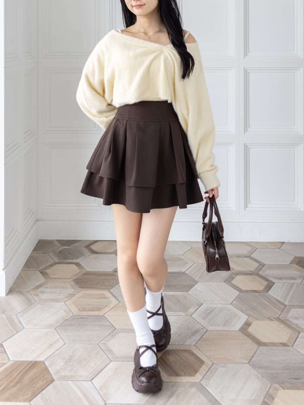 ブラウン系のハンドバッグ、ブラウン系のサンダル、ブラウン系のスカートを着用したレディースの秋コーディネートの1枚目の写真