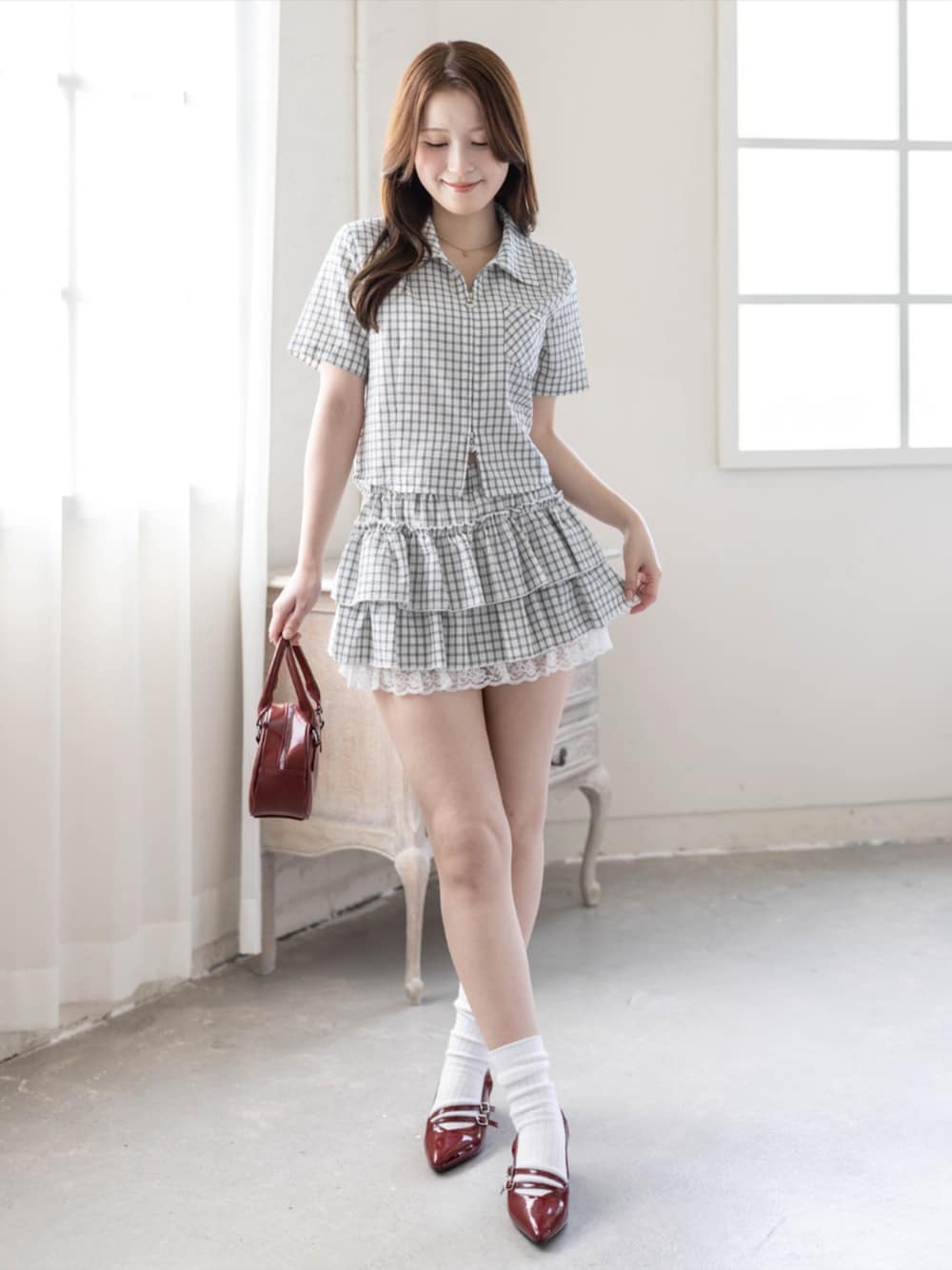 レッド系のパンプス、ホワイト系のスカート、ホワイト系のシャツ/ブラウスを着用したレディースの春コーディネートの1枚目の写真