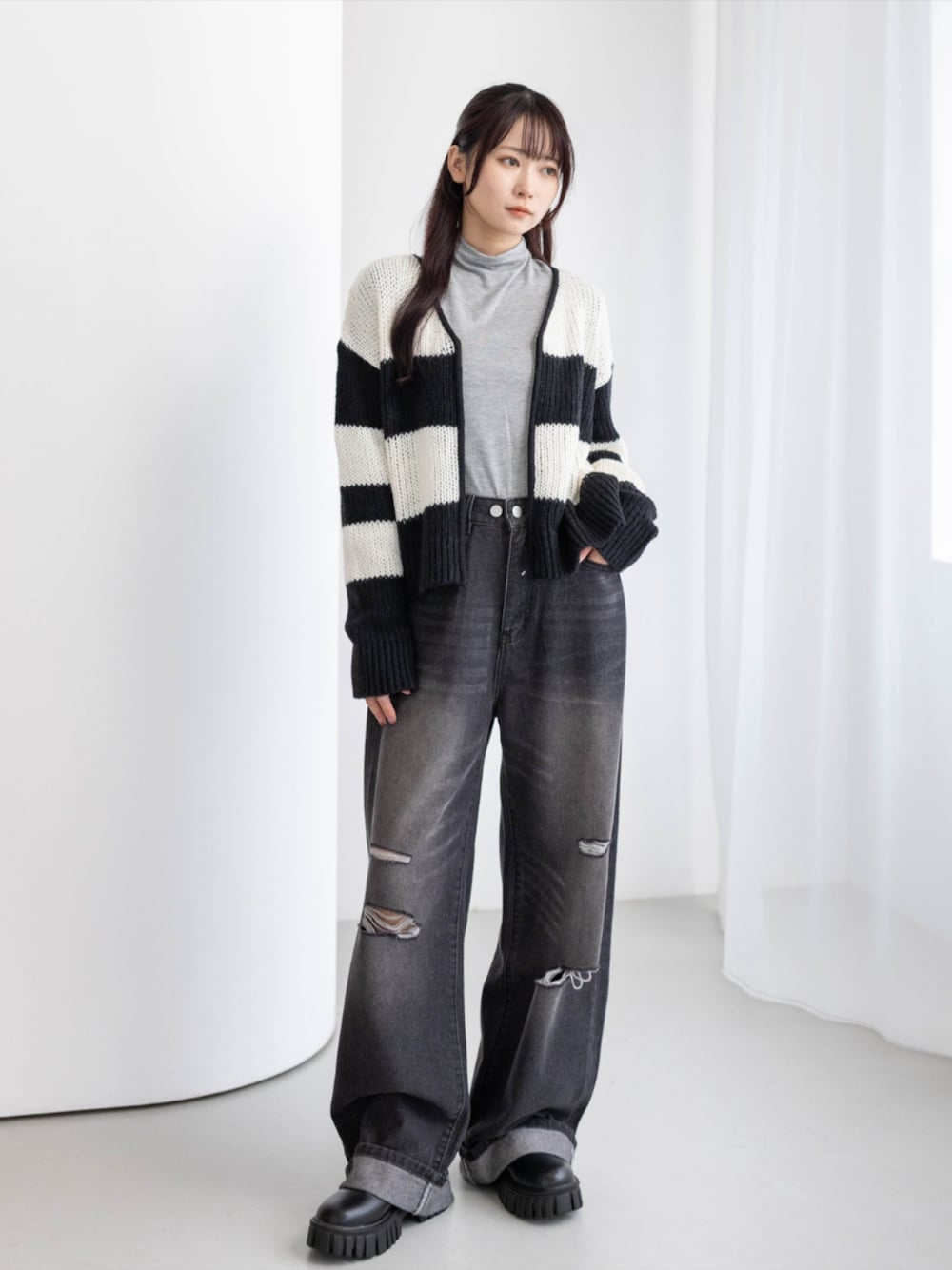 グレー系のTシャツ/カットソー、ブラック系のデニムパンツ、ブラック系のブーツを着用したレディースの秋コーディネートの1枚目の写真