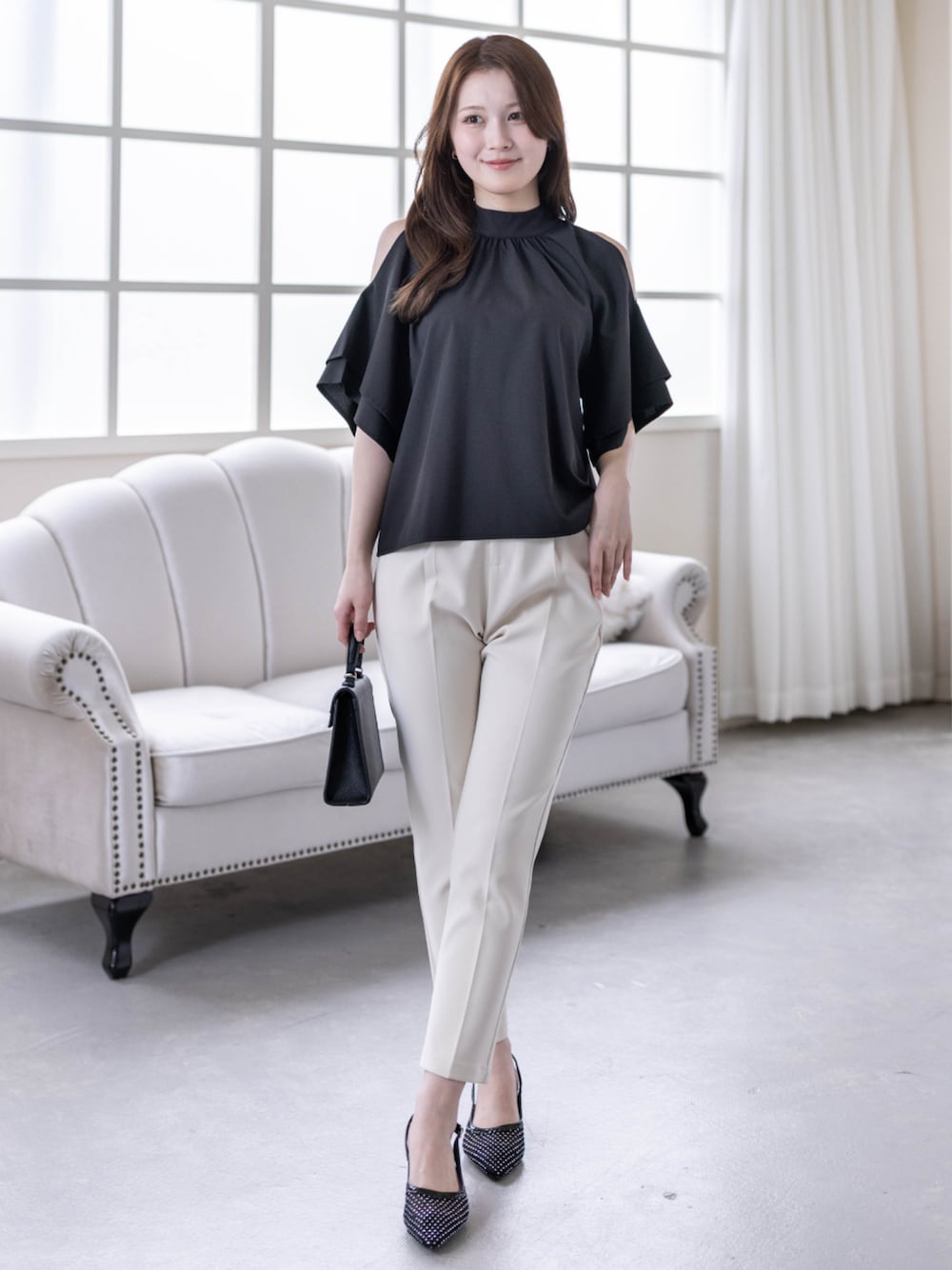 ホワイト系のその他パンツ、ブラック系のハンドバッグ、ブラック系のパンプスを着用したレディースの春コーディネートの1枚目の写真