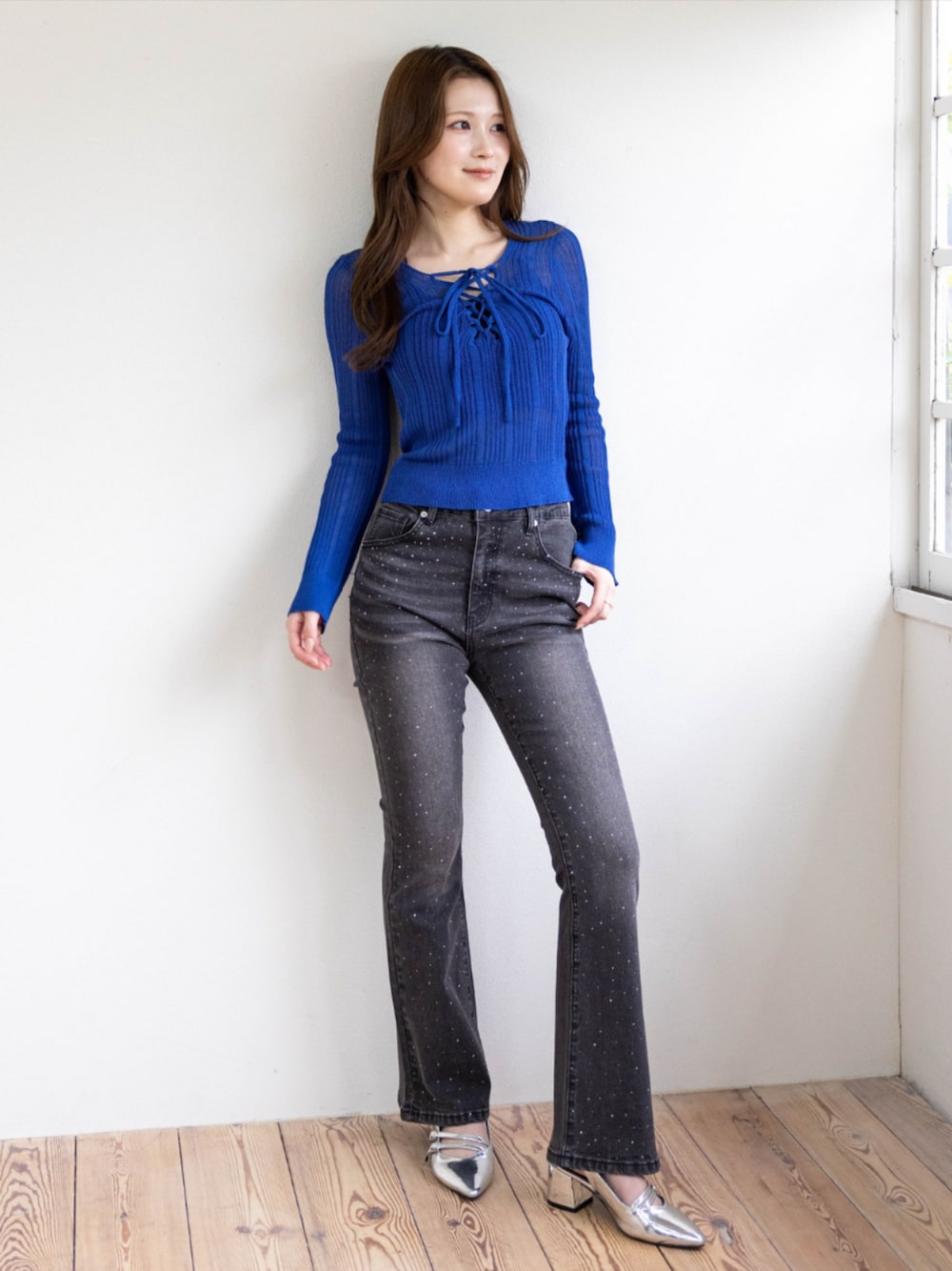 シルバー系のパンプス、ブラック系のデニムパンツ、ブルー系のニット/セーターを着用したレディースの春コーディネートの1枚目の写真