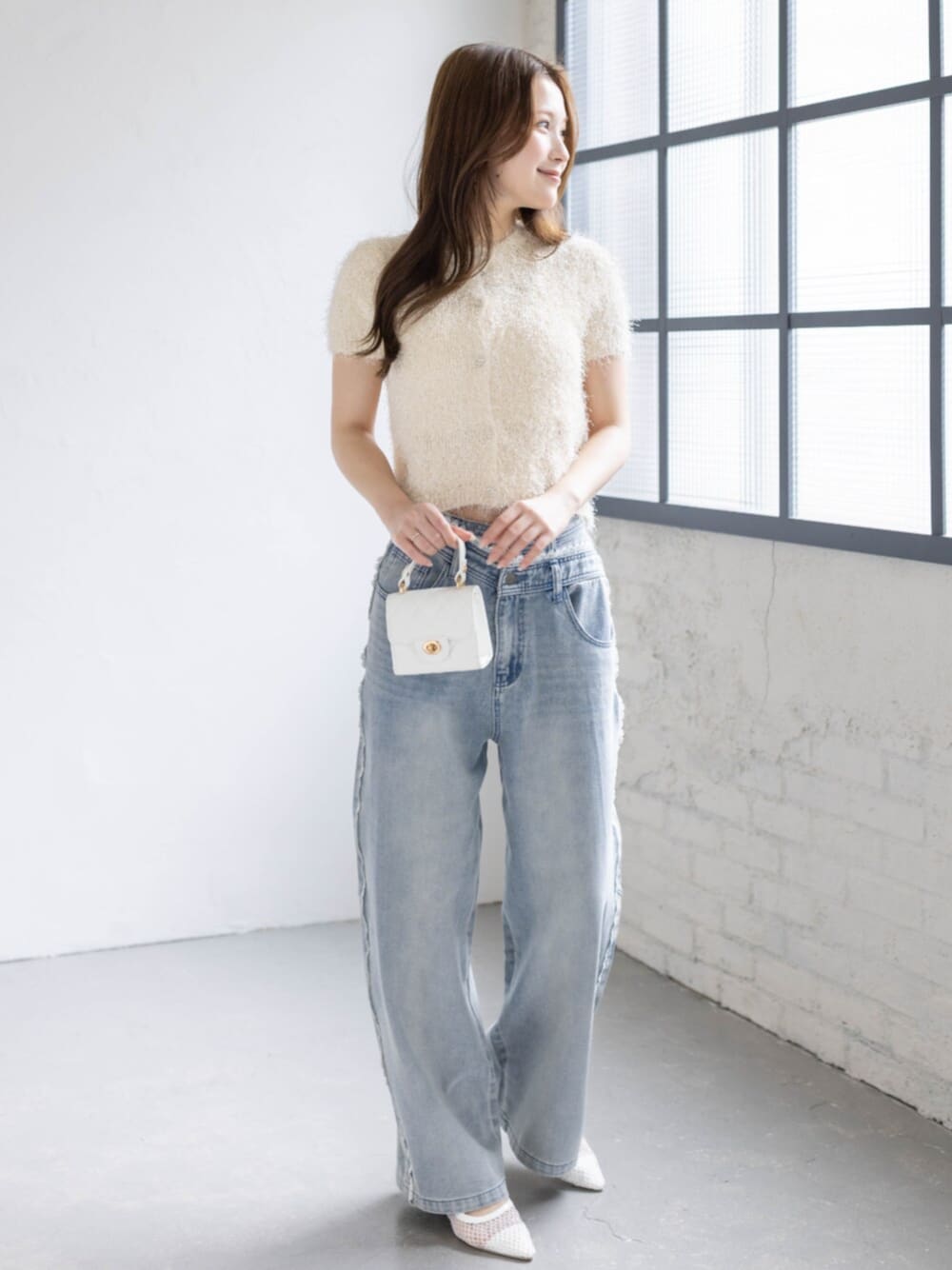 ホワイト系のパンプス、ホワイト系のカーディガン/ボレロ、ブルー系のデニムパンツを着用したレディースの春コーディネートの1枚目の写真