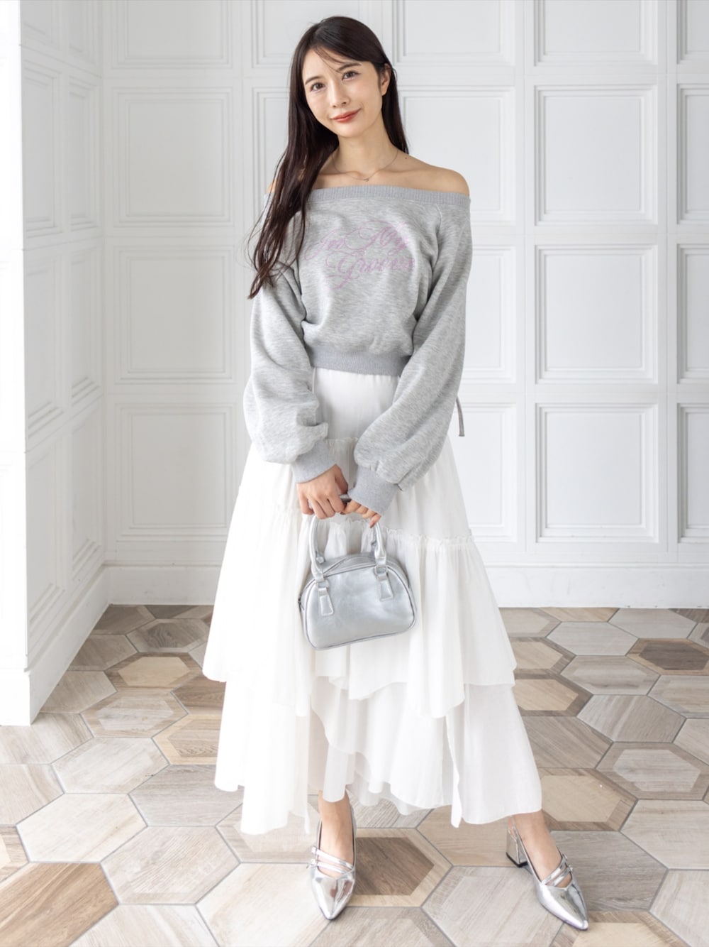 シルバー系のハンドバッグ、シルバー系のサンダル、ホワイト系のスカートを着用したレディースの秋コーディネートの1枚目の写真