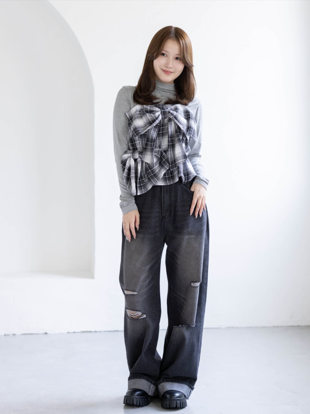 グレー系のTシャツ/カットソー、ブラック系のデニムパンツ、ブラック系のブーツを着用したレディースの秋コーディネートの1枚目の写真
