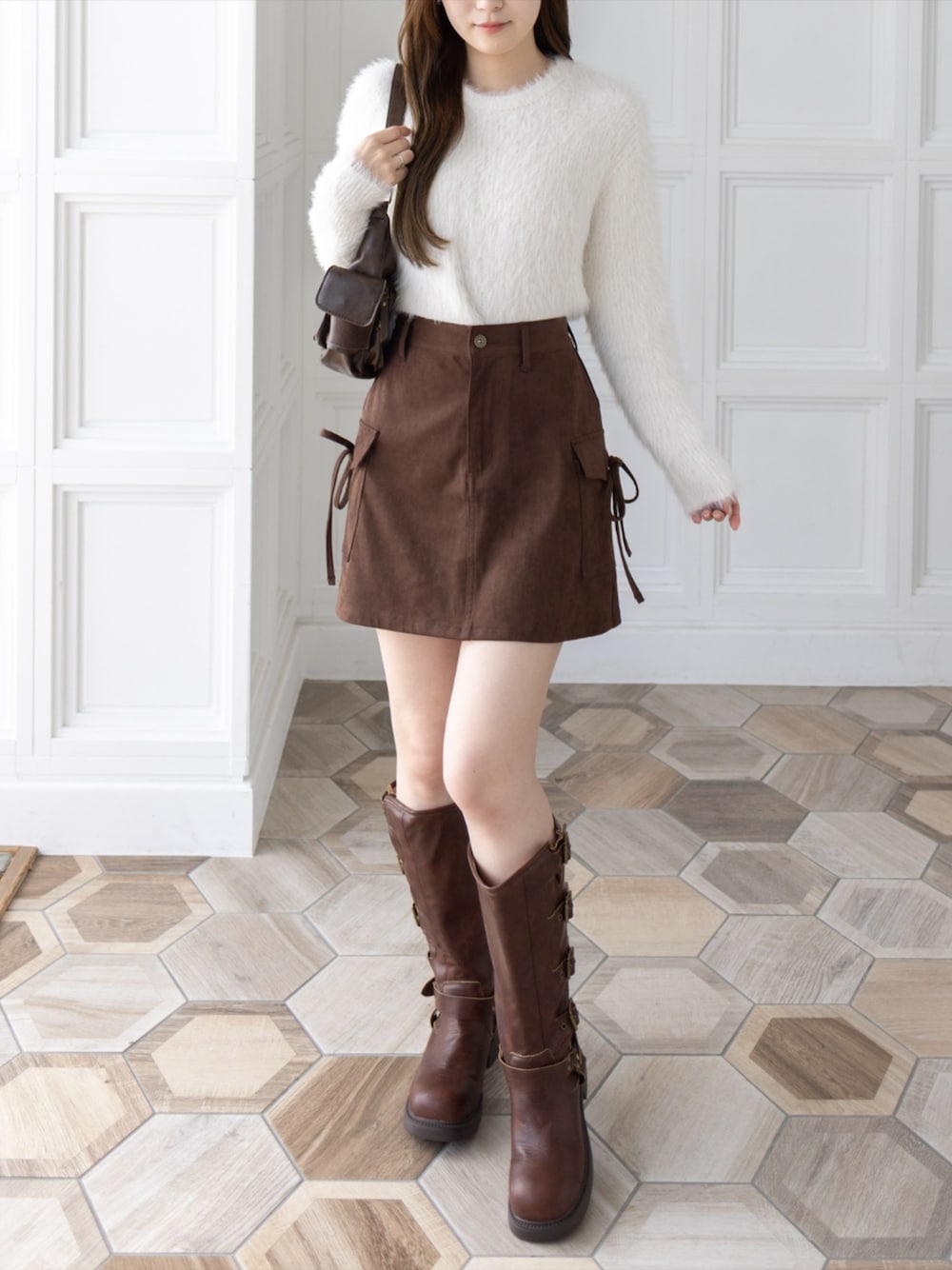 ブラウン系のブーツ、ブラウン系のハンドバッグ、ブラウン系のスカートを着用したレディースの秋コーディネートの1枚目の写真