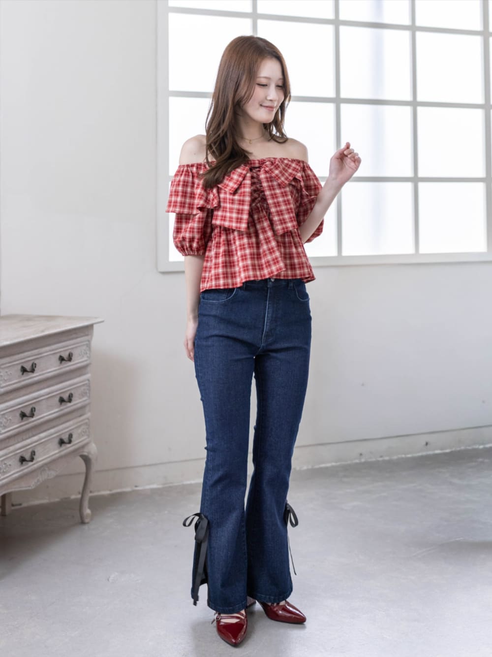 レッド系のパンプス、レッド系のシャツ/ブラウス、ブルー系のデニムパンツを着用したレディースの春コーディネートの1枚目の写真