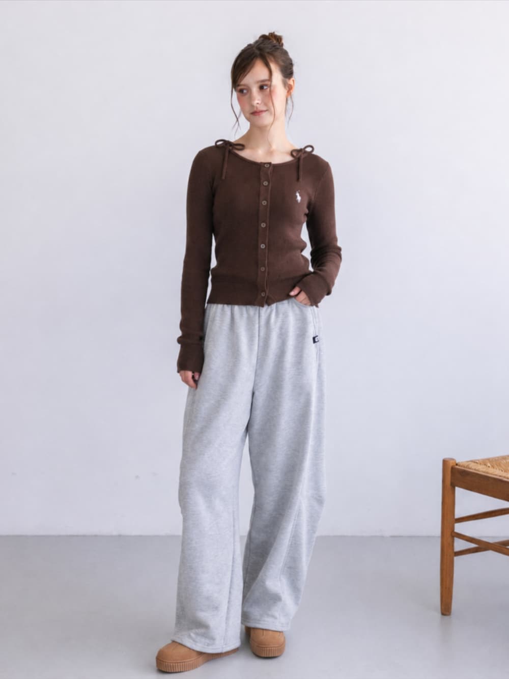 グレー系のスウェットパンツ、イエロー系のスニーカー、ブラウン系のニット/セーターを着用したレディースの秋コーディネートの1枚目の写真