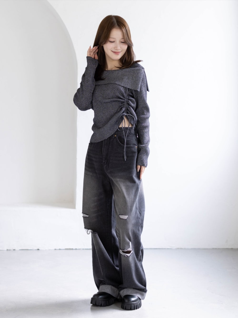 ブラック系のデニムパンツ、ブラック系のブーツ、ブラック系のニット/セーターを着用したレディースの秋コーディネートの1枚目の写真