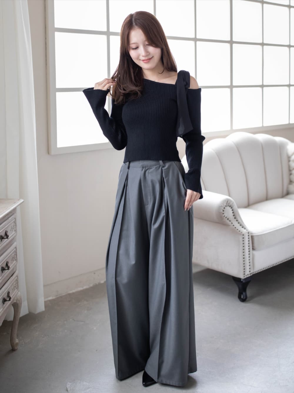 グレー系のその他パンツ、ブラック系のパンプス、ブラック系のニット/セーターを着用したレディースの秋コーディネートの1枚目の写真