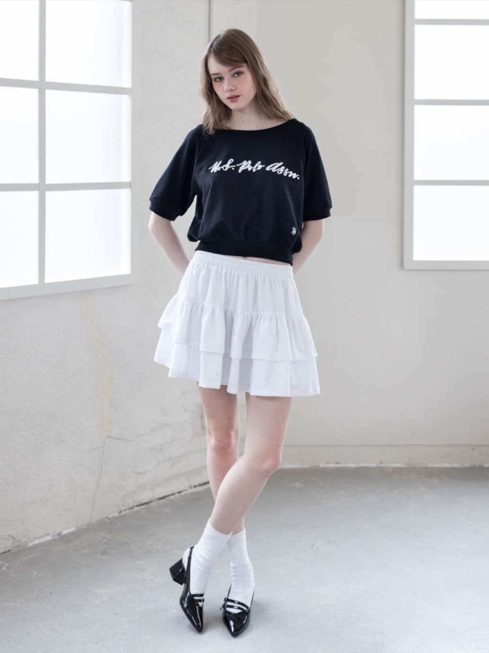 ブラック系のパンプス、ホワイト系のスカート、ブラック系のTシャツ/カットソーを着用したレディースの夏コーディネートの1枚目の写真