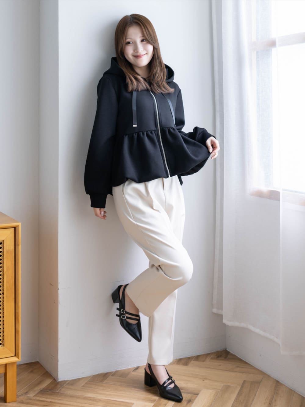 ホワイト系のその他パンツ、ブラック系のパンプス、ブラック系のパーカーを着用したレディースの秋コーディネートの1枚目の写真
